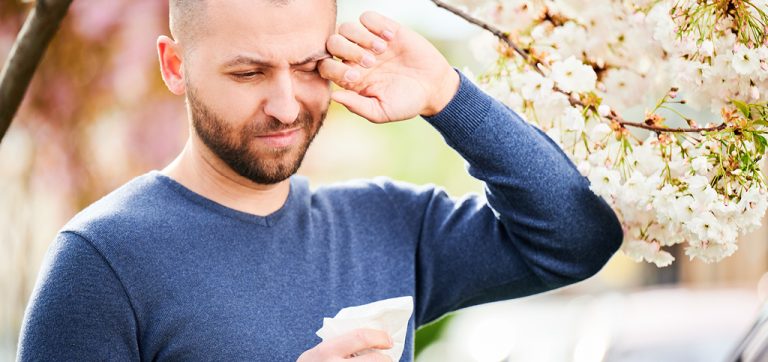 איש מגרד את עיניו ליד עץ שקדיה